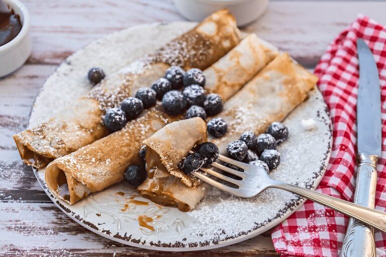 Crepes Vegane sottili e dorate, servite con frutta fresca e sciroppo d'acero