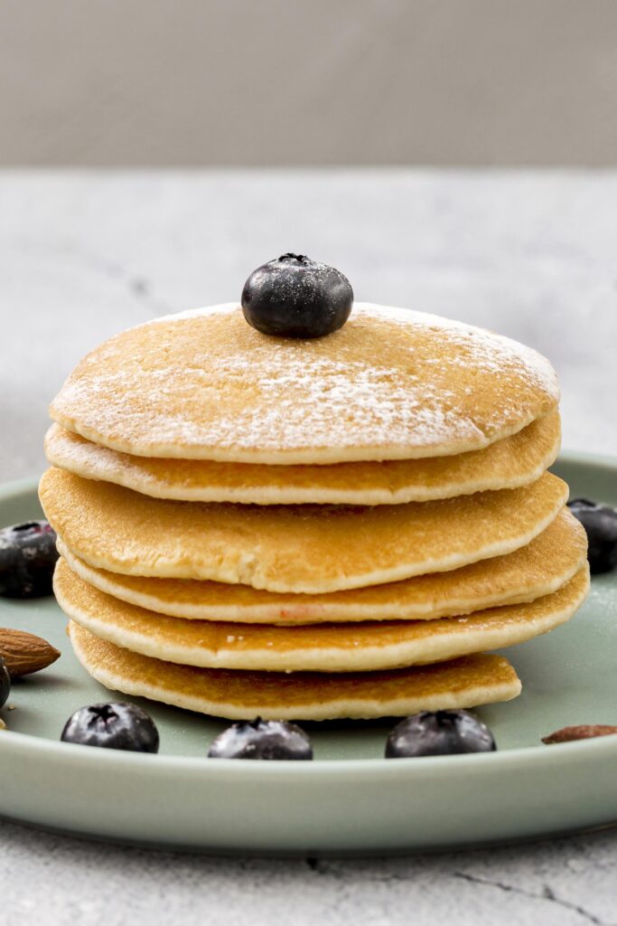 Pancake vegani soffici serviti con sciroppo d'acero e frutta fresca.