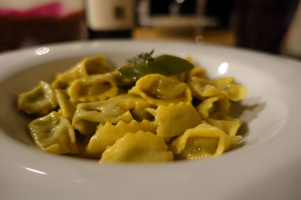 Ravioli del Plin tradizionali piemontesi, ripieni di carne, serviti con salsa al burro e salvia fresca