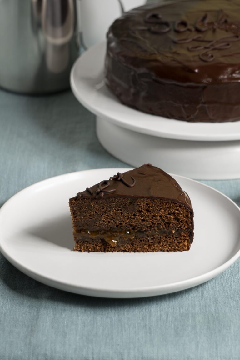 Torta al cioccolato soffice e ricca con glassa al cioccolato, decorata con fragole fresche e granella di nocciole