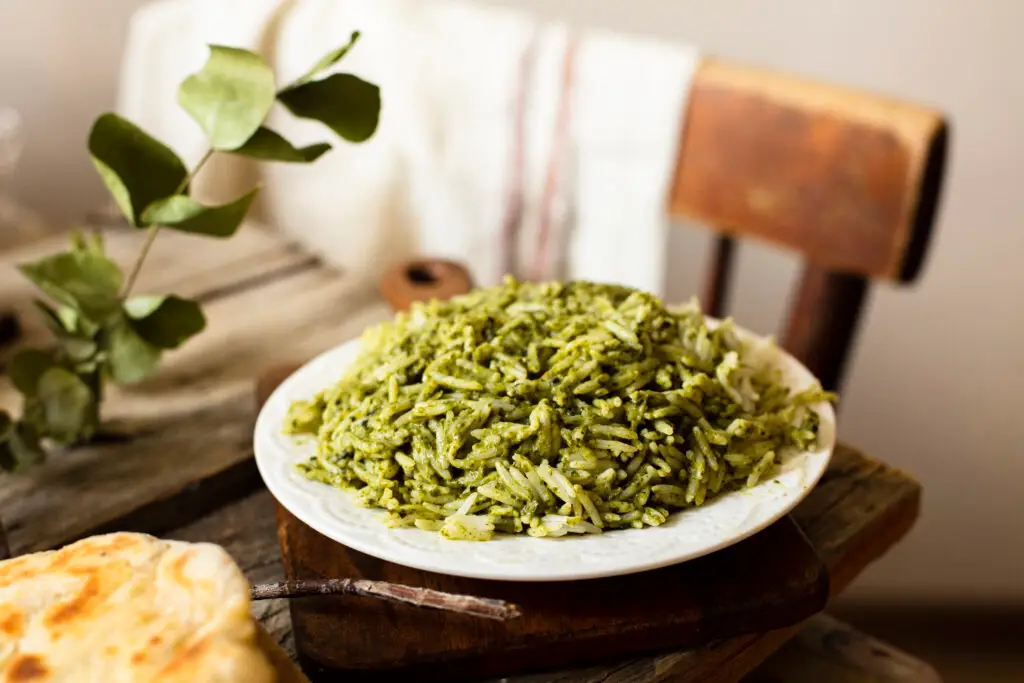 Pasta al pesto genovese guarnita con basilico fresco.