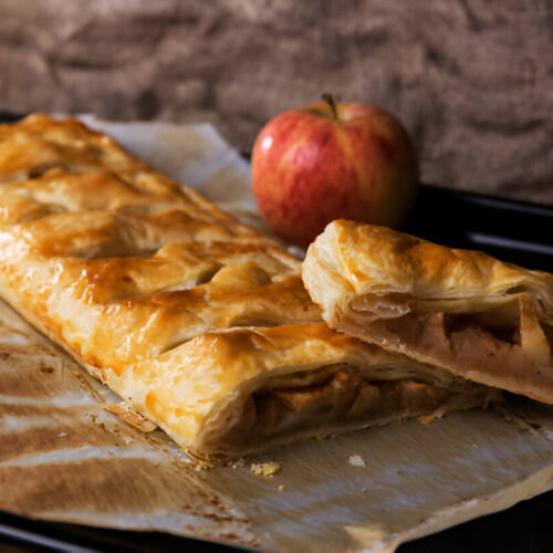 Strudel di mele dorato e croccante servito su un piatto elegante