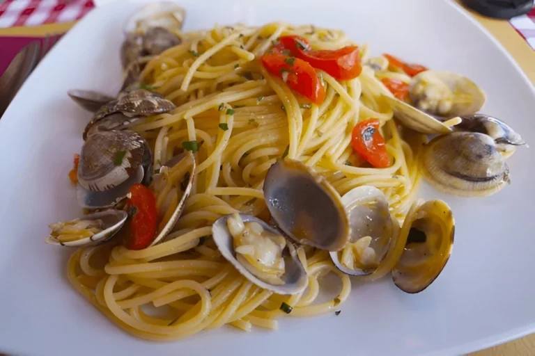 Piatto di spaghetti alle vongole fumanti, con prezzemolo fresco